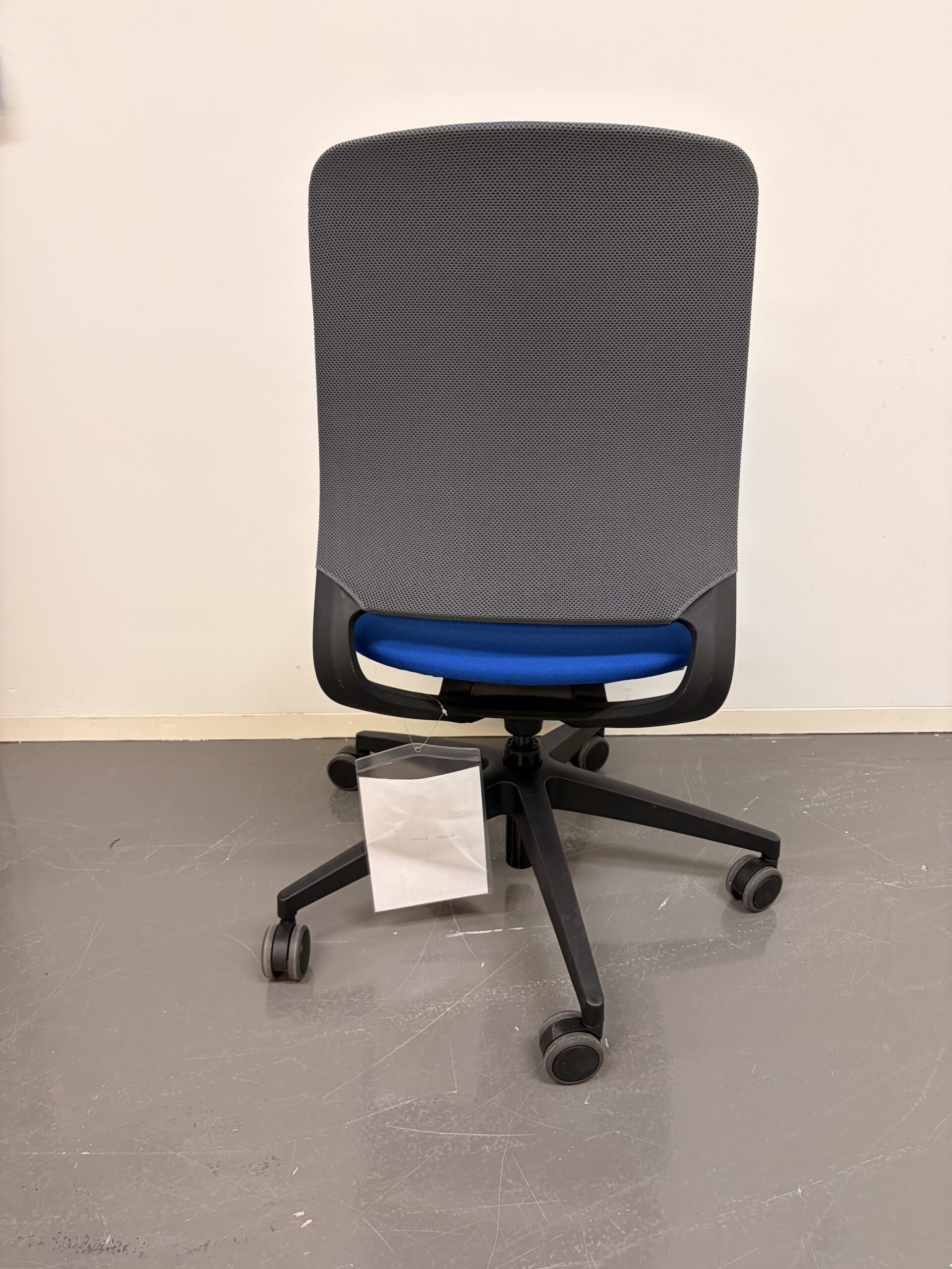 Bürostuhl mit blau gepolstertem Sitz und Rückenlehne auf schwarzem Gestell mit fünf Rollen hinten