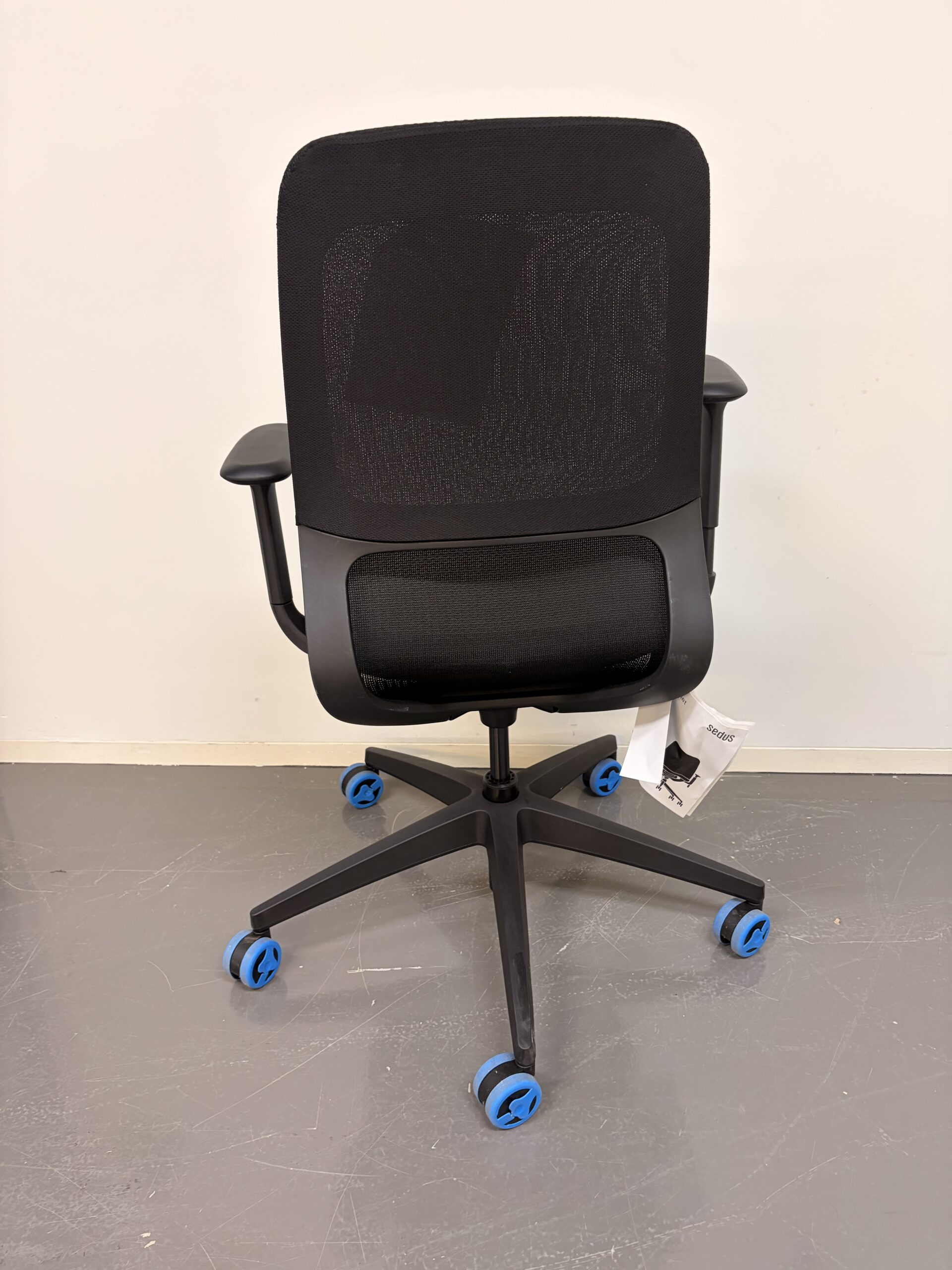 Bürostuhl mit schwarzer Netzrückenlehne, grauem Sitzpolster und schwarzen Armlehnen hinten