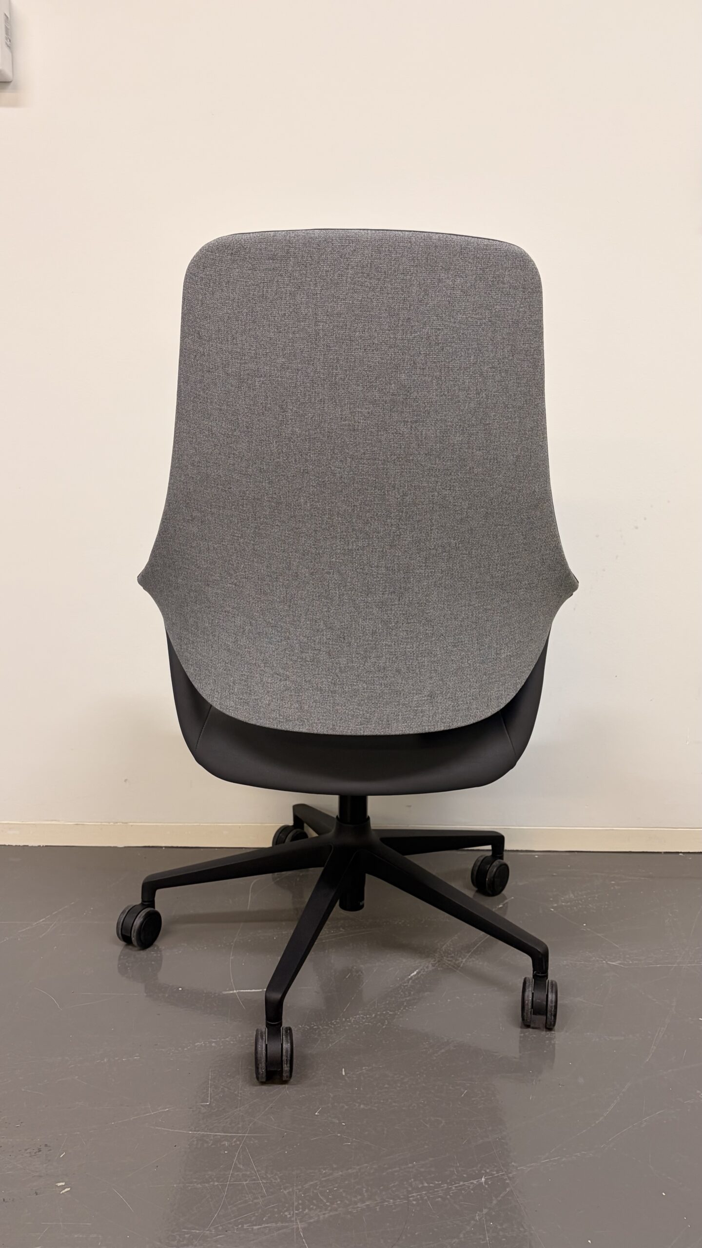 Moderner Bürostuhl mit fünf Rollen auf schwarzem Gestell hinten
