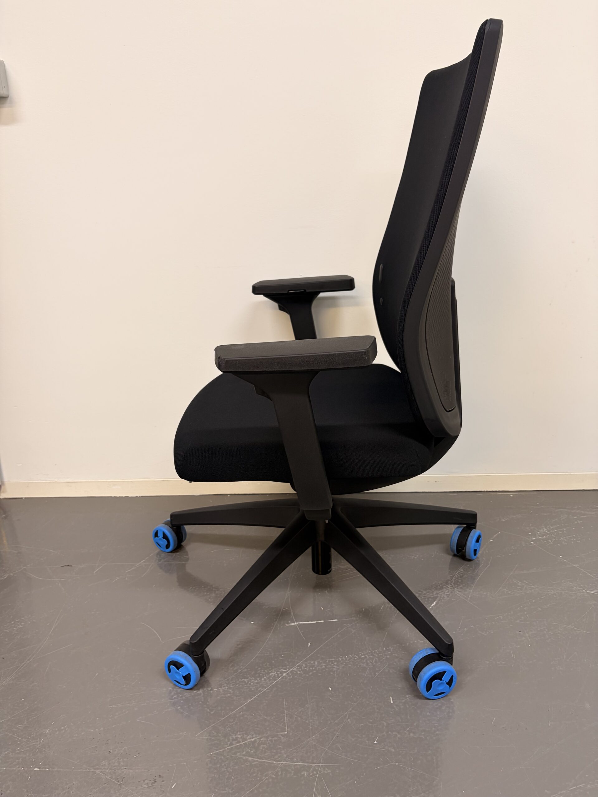 Schwarzer Bürostuhl mit hoher Rückenlehne, Armlehnen und schwarzem Gestell seite