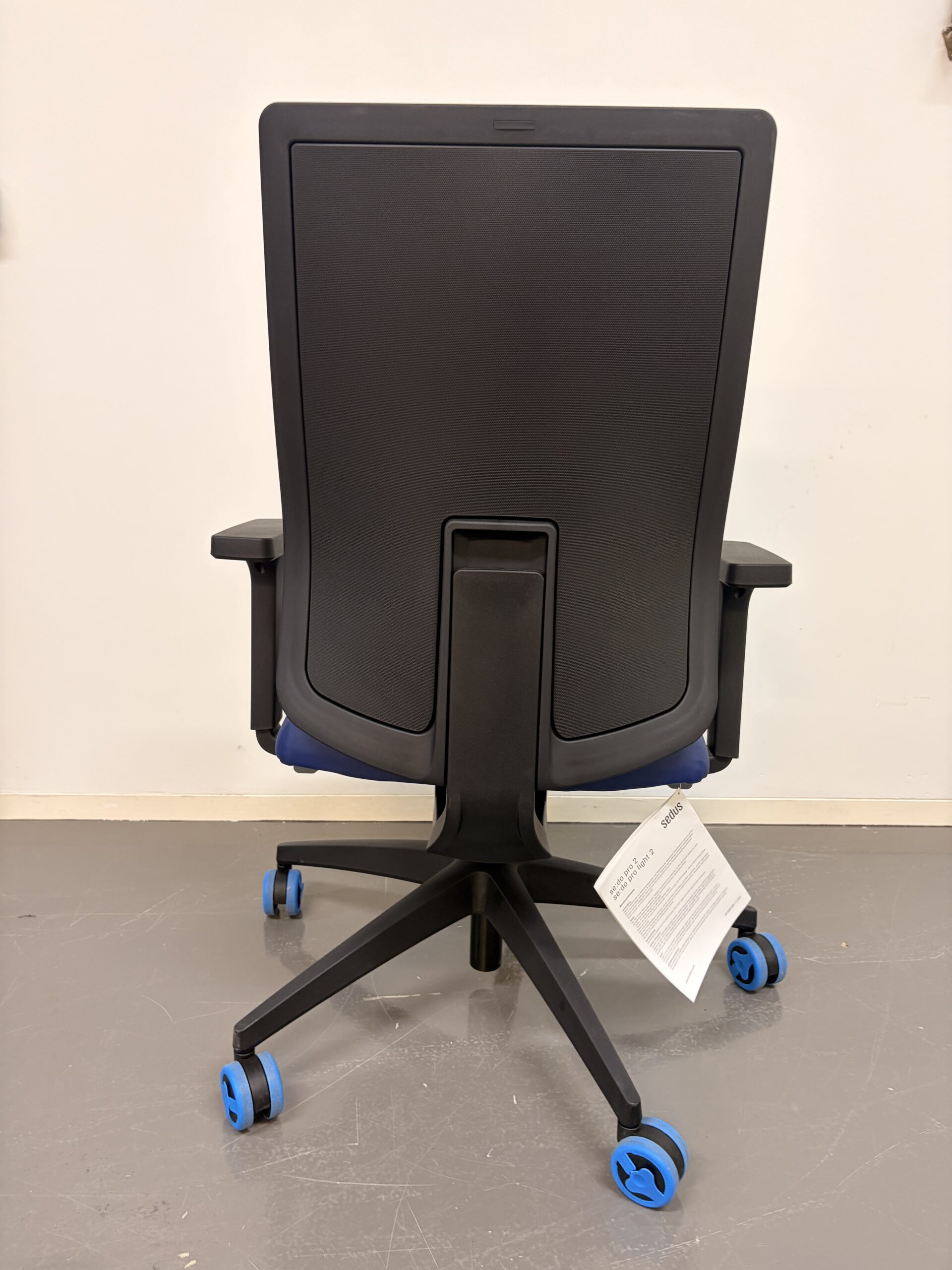 Bürostuhl mit blauer Polsterung, schwarzem Gestell und Armlehnen hinten