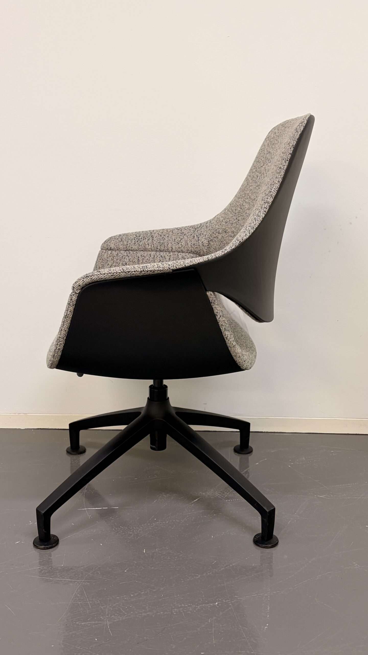 Moderner Bürostuhl mit grauem Stoffbezug und schwarzem Kunststoffrücken seitlich